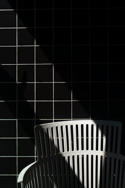 黑色地砖上的白色塑料洗衣篮